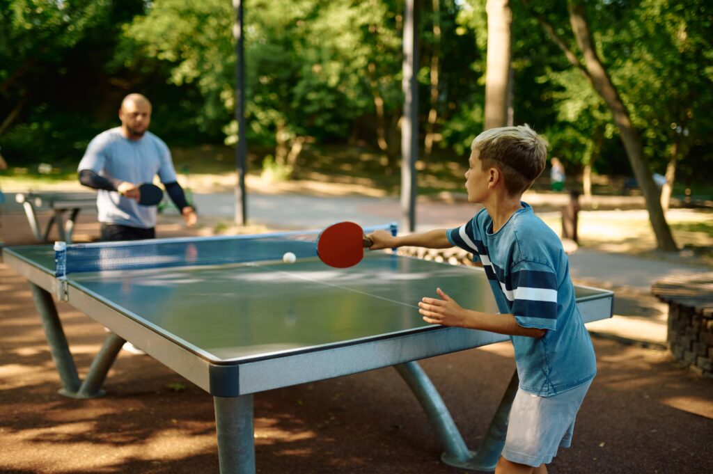 father-and-son-play-table-tennis-outdoors-2022-01-19-00-17-21-utc